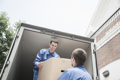 Boxes, wrapped furniture, and moving equipment prepared for a Sutton flat removal